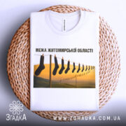 Футболка межа Житомирської області, білого кольору, складена на плетеній основі, фон натуральний, принт з шкарпетками на мотузці, видно етикетку на горловині.