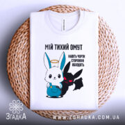 Футболка мій тихий омут. Біла футболка, складена на плетеній основі, з принтом, що зображує заєць і демон. Принт яскравий, з чіткими кольорами, фон нейтральний, акцент на малюнку.