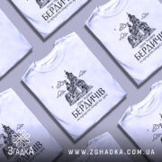 Футболка місто Бердичів подарунок, біла, зображена на манекені, фон світло-сірий, принт з архітектурним зображенням церкви та текстом на українській мові.
