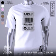 Футболка місто Харків, біла, зображена на манекені, фон світло-сірий, принт у вигляді етикетки з написом 'ХАРКІВ', містить графічні елементи, такі як штрих-код і символи, що підкреслюють тематику науки та свободи.