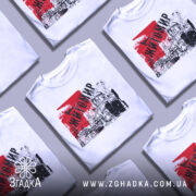 Футболка місто Житомир, біла, зображена на манекені, фон світло-сірий, принт містить червоний фон з написом 'Житомир' та графічним зображенням архітектури.