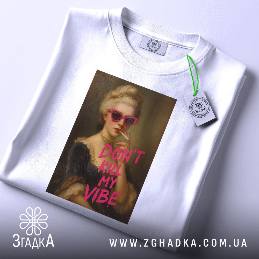 Футболка модний арт, біла, зображена на столі, фон світло-сірий, принт з портретом жінки в рожевих окулярах, напис 'DON'T KILL MY VIBE' яскраво-рожевого кольору, на футболці є етикетка.