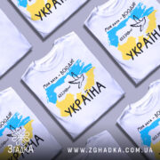 Футболка моя хата всюди, біла футболка з коротким рукавом, зображена на манекені, фон нейтральний, принт містить карту України з жовто-блакитними кольорами, напис '603.548км²' та малюнок голуба.