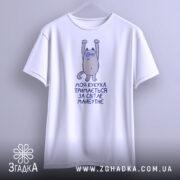 Футболка моя кукуха тримається на манекені, білого кольору, з принтом на грудях, зображаючим персонажа з піднятими руками, фон градієнтний сірий.