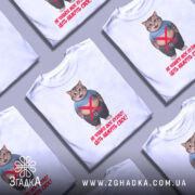 Футболка моє пузіко, біла, зображена з фронтального ракурсу на манекені, фон світло-сірий, принт з веселим котом у синій футболці та текстом червоного кольору.