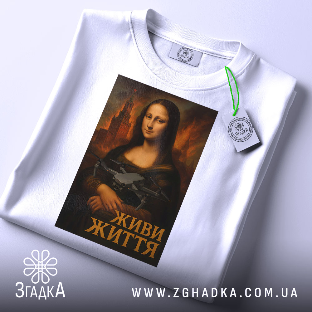 Футболка Мона Ліза дрон білого кольору, зображена зверху, на ній підвішений тег, фон світлий, принт з Моною Лізою, яка тримає дрон, підпис "ЖИВИ ЖИТТЯ" внизу.
