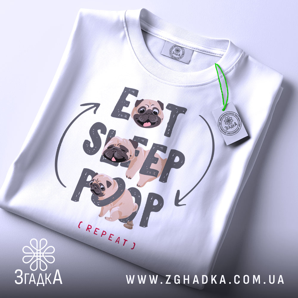 Футболка мопс ритуал, біла, складена на поверхні, фон світло-сірий, принт з текстом 'EAT SLEEP POOP (REPEAT)' та малюнками мопсів, на футболці є етикетка з зеленим шнурком.