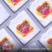 Футболка мозок під напругою, біла, зображена на манекені, фон світло-сірий, принт з яскравими кольорами: жовтий, рожевий, блакитний, з зображенням мозку в руках.