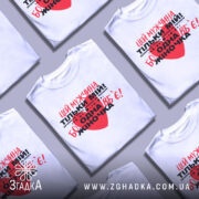 Футболка мужчина мій, біла, зображена на манекені, фон нейтральний, принт червоний та чорний з текстом, що містить серце.