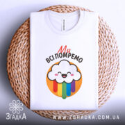 Футболка ми всі помремо, біла, зображена в складеному вигляді на плетеній основі, фон світло-сірий, принт з хмаринкою та кольоровими краплями.