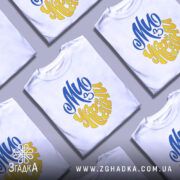 Футболка ми з України білого кольору, зображена з фронтального ракурсу на манекені, фон світло-сірий, принт виконаний у синьому та жовтому кольорах, напис "Ми з України" розташований по центру.