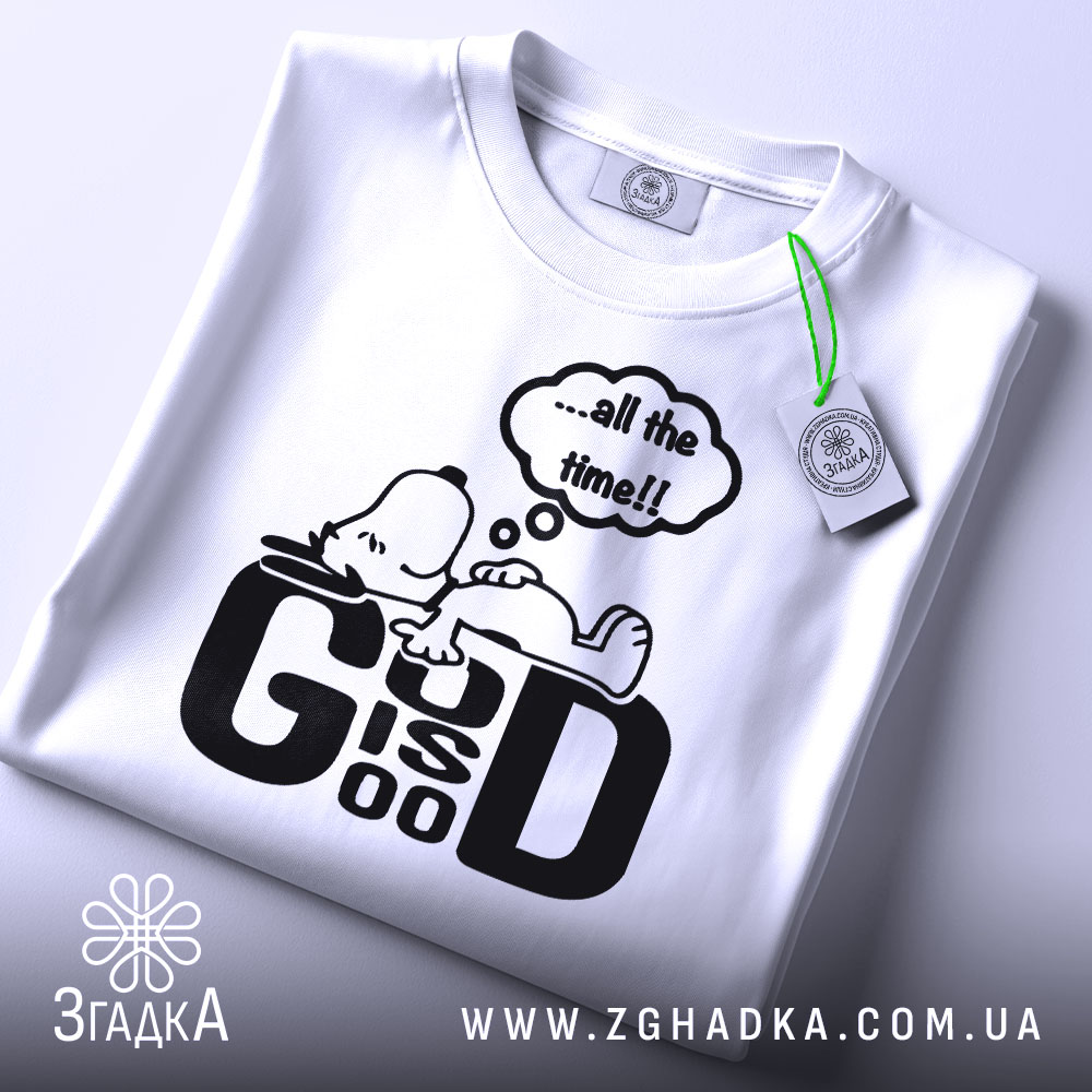 Футболка мир серце біла, зображена на столі, фон світло-сірий, принт чорний з персонажем, що лежить, та текстом '...all the time!!', з етикеткою зеленого кольору.