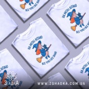 Футболка на мітлі літаю — кілька складених футболок, композиція на столі.