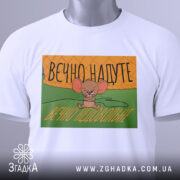 Футболка надуте недовольне, біла, зображена з верхнього ракурсу, фон нейтральний, принт з малюнком мишеняти, яке виглядає незадоволено, текст на принті українською мовою: 'ВЕЧНО НАДУТЕ ВЕЧНО НЕДОВОЛЬНЕ', на футболці є етикетка з зеленим шнурком.