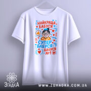 Футболка найкраща бабуся у світі, біла, підвішена на вішалці, фон світло-сірий, принт з малюнком бабусі в окулярах, з сердечками та написами у яскравих кольорах.