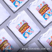 Футболка найкраща мама, біла, зображена на манекені, фон світло-сірий, принт з яскравими кольорами, з малюнком обличчя жінки з блакитним волоссям та сердечками.