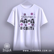 Футболка найкраща мама, білого кольору, зображена з фронтального ракурсу на вішалці, фон світло-сірий, принт з квітами та написом "Найкраща мама в світі" в чорному та фіолетовому кольорах.