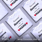 Футболка найкраща мама, біла, зображена на манекені, фон світло-сірий, принт чорний з червоними сердечками, текст українською мовою.