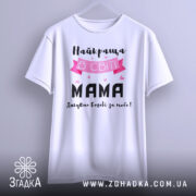 Футболка найкраща мама, білого кольору, зображена на манекені, фон світло-сірий, принт з текстом "Найкраща в світі МАМА" з рожевими елементами та сердечками.