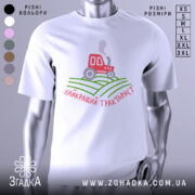 Футболка найкращий тракторист. Біла футболка з коротким рукавом, зображена з фронтального ракурсу на манекені. На фоні світло-сірий колір. Принт містить червоний трактор, що курить, на зелених полях, з написом 'найкращий тракторист' у червоному кольорі.