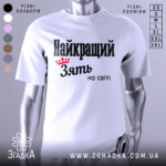 Футболка найкращий зять, біла, зображена на манекені, фон світло-сірий, принт чорного кольору з червоною короною та текстом 'Найкращий зять на світі'.