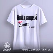 Футболка найкращий зять, біла, підвішена на вішалці, фон світло-сірий, принт чорного кольору з червоною короною та текстом 'Найкращий зять на світі'.