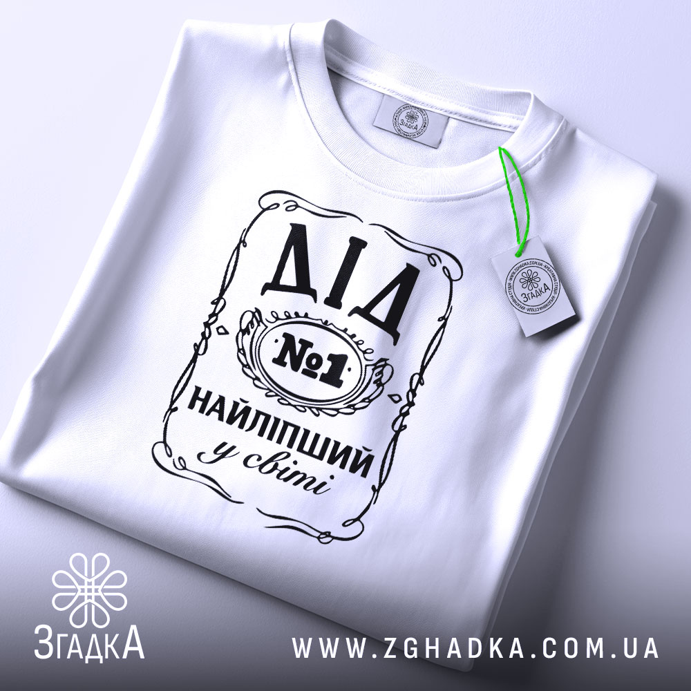 Футболка найліпший дід, білого кольору, зображена зверху на плоскій поверхні, фон світло-сірий, принт чорного кольору з написом 'ДІД №1 НАЙЛІПШИЙ у світі', на футболці є етикетка з зеленим шнурком.