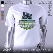 Футболка найліпший тракторист. Біла футболка з коротким рукавом, зображена на манекені з металевим блиском. На фоні світло-сірий колір. Принт з трактором та написом 'НАЙЛІПШИЙ ТРАКТОРИСТ' у зелених та чорних тонах.