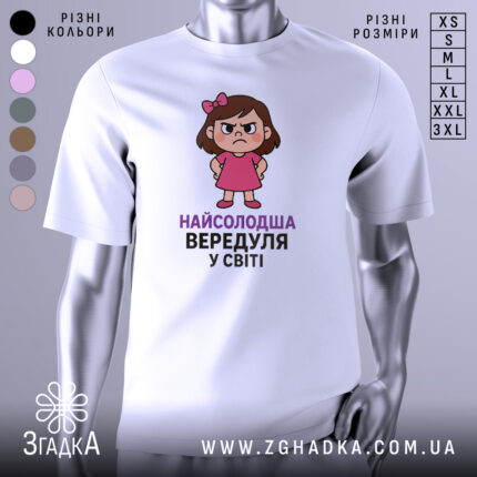 Футболка найсолодша вередуля, білого кольору, зображена з фронтального ракурсу на манекені, фон має легкий градієнт, принт з малюнком дівчинки у рожевій сукні з серйозним виразом обличчя та написом 'НАЙСОЛОДША ВЕРЕДУЛЯ У СВІТІ'.