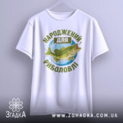 Футболка народжений для риболовлі, білого кольору, зображена з фронтального ракурсу, фон світло-сірий, принт з рибою та текстом в зелених відтінках.