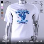 Футболка народжений рибалити, білого кольору, зображена з близького ракурсу на манекені, фон нейтральний, принт з рибою та текстом виконаний у блакитних тонах.