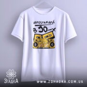 Футболка народжений в 90, біла, підвішена на вішалці, фон світлий, принт з жовтим магнітофоном і касетами, текст чорний, виглядає стильно.