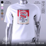 Футболка наш борщ. Біла футболка на манекені, з принтом у вигляді банки борщу, на фоні світло-сірого кольору. Принт містить червоний та зелений кольори, з написом '100% український' та 'УКРАЇНСЬКИЙ БОРЩ'.