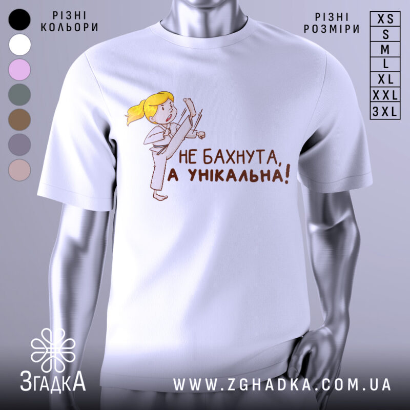 Футболка не бахнута унікальна, білого кольору, зображена з фронтального ракурсу на манекені, фон світло-сірий, принт з дівчинкою у кімоно, яка виконує удар, текст чорного кольору: 'НЕ БАХНУТА, А УНІКАЛЬНА!'