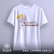 Футболка не бахнута унікальна, білого кольору, підвішена на вішалці, фон світло-сірий, принт з дівчинкою у кімоно, яка виконує удар, текст чорного кольору: 'НЕ БАХНУТА, А УНІКАЛЬНА!'.