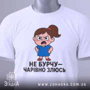 Футболка не бурчу. Біла футболка, зображена з верхнього ракурсу, на ній малюнок сердитої дівчинки в синій сукні, текст чорного кольору, на комірці видно етикетку.