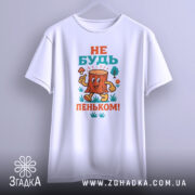 Футболка не бути пеньком. Біла футболка, підвішена на вішалці, з кольоровим принтом пенька, який усміхається. Ракурс спереду, фон світло-сірий.