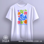 Футболка не бзди, біла, зображена з фронтального ракурсу, фон світло-сірий, принт з яскравими квітами та текстом "НЕ БЗДИ" у синьому кольорі.