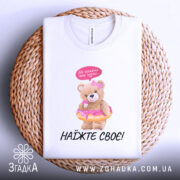 Футболка не чіпайте пузіко. Біла футболка, зображена на плетеній основі, ведмедик у купальнику з пончиком, на фоні світло-сірого градієнту. Принт яскравий, ведмедик тримає пончик, зверху напис "Не чіпайте моє пузіко...".