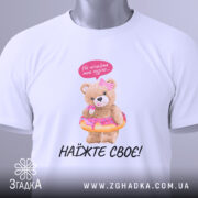 Футболка не чіпайте пузіко. Біла футболка, зображена з верхнього ракурсу, ведмедик у купальнику з пончиком, на фоні світло-сірого градієнту. Принт яскравий, ведмедик тримає пончик, зверху напис "Не чіпайте моє пузіко...". На футболці є етикетка.