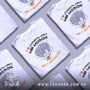 Футболка не довбіть мозок, біла, зображена на манекені, фон світлий, принт з малюнком мозку та текстом "Не добийте мені МІЙ МОЗОК ВІН У ВІДПУСТЦІ!!" у чорному та оранжевому кольорах.