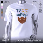 Футболка не ти без бороди. Біла футболка з коротким рукавом, зображена на манекені з нейтральним фоном. Принт містить текст 'ТИ не ти КОЛИ БЕЗ БОРОДИ' з малюнком бороди, виконаним у коричневих тонах.