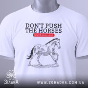 Футболка не жени коней, біла, зображена на манекені, фон однотонний, принт з конем у стилі малюнка, текст червоний на чорному.