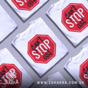 Футболка не зупинити, біла, зображена з фронтального ракурсу на манекені, фон світло-сірий, принт у вигляді червоного знака стоп з написом 'CAN'T STOP US!' чорними буквами та краплинами фарби.