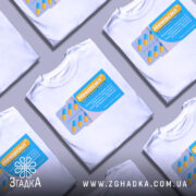 Футболка немасил терпіти, біла, зображена на манекені з правого боку, фон світло-сірий, принт зображає упаковку з капсулами, з жовтими та блакитними елементами, текст на принті українською мовою.