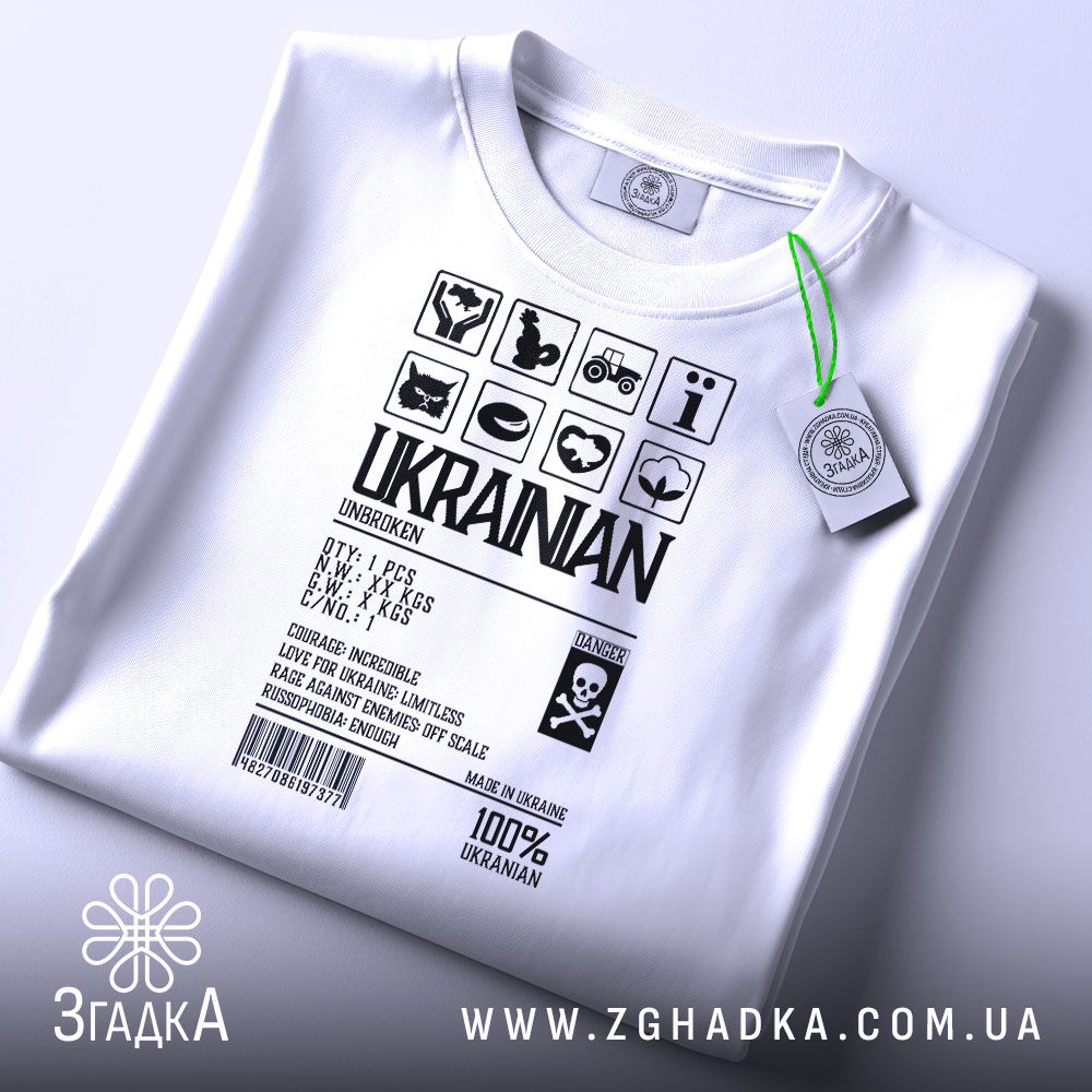 Футболка незламний українець, білого кольору, зображена з верхнього ракурсу, фон світло-сірий, принт чорного кольору з символами та текстом, на комірці є етикетка з зеленим шнурком.