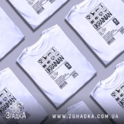 Футболка незламний українець, білого кольору, зображена з фронтального ракурсу на манекені, фон світло-сірий, принт чорного кольору з символами та текстом, що підкреслює українську ідентичність.