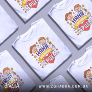 Футболка няня, білого кольору, зображена з фронтального ракурсу на манекені, фон світло-сірий, принт з двома дітьми, серцем та написом 'няня з великим серцем'.