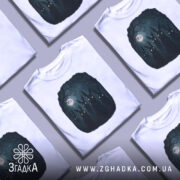 Футболка нічна таємниця, біла, зображена на манекені, фон світло-сірий, принт з п'ятьма чорними зайцями з яскравими очима на темному фоні з місяцем.