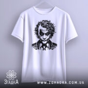 Футболка нічний бунтар, біла, підвішена на вішалці, фон світло-сірий, принт з чорним малюнком обличчя персонажа з кучерявим волоссям і костюмом.